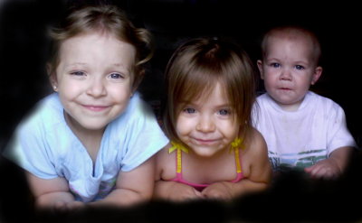 THree kids leaning over toy box